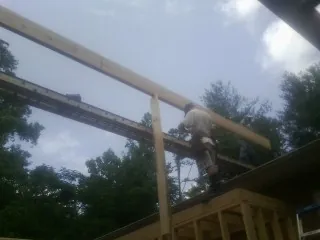 Carpenter setting a ridge beam over a new addition frame — Ice Dam Removal by Roofing Brothers in Mansfield